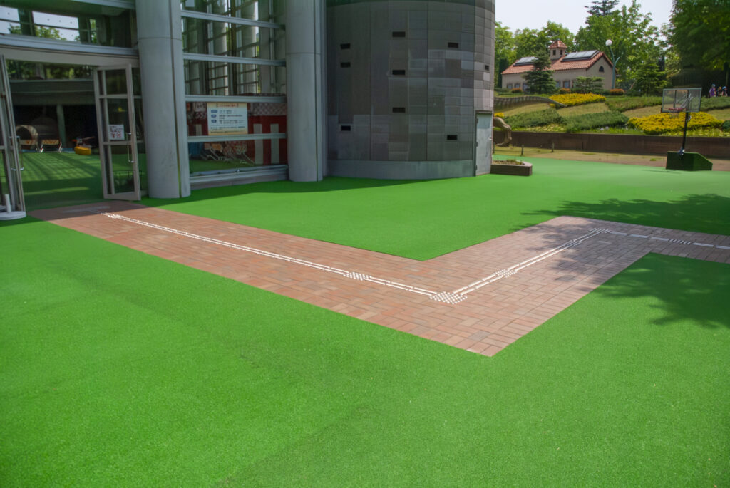 栃木県立とちぎわんぱく公園の広場｜ノンフィル人工芝×段差ゼロ×点字ブロック｜安全・清掃性・景観性