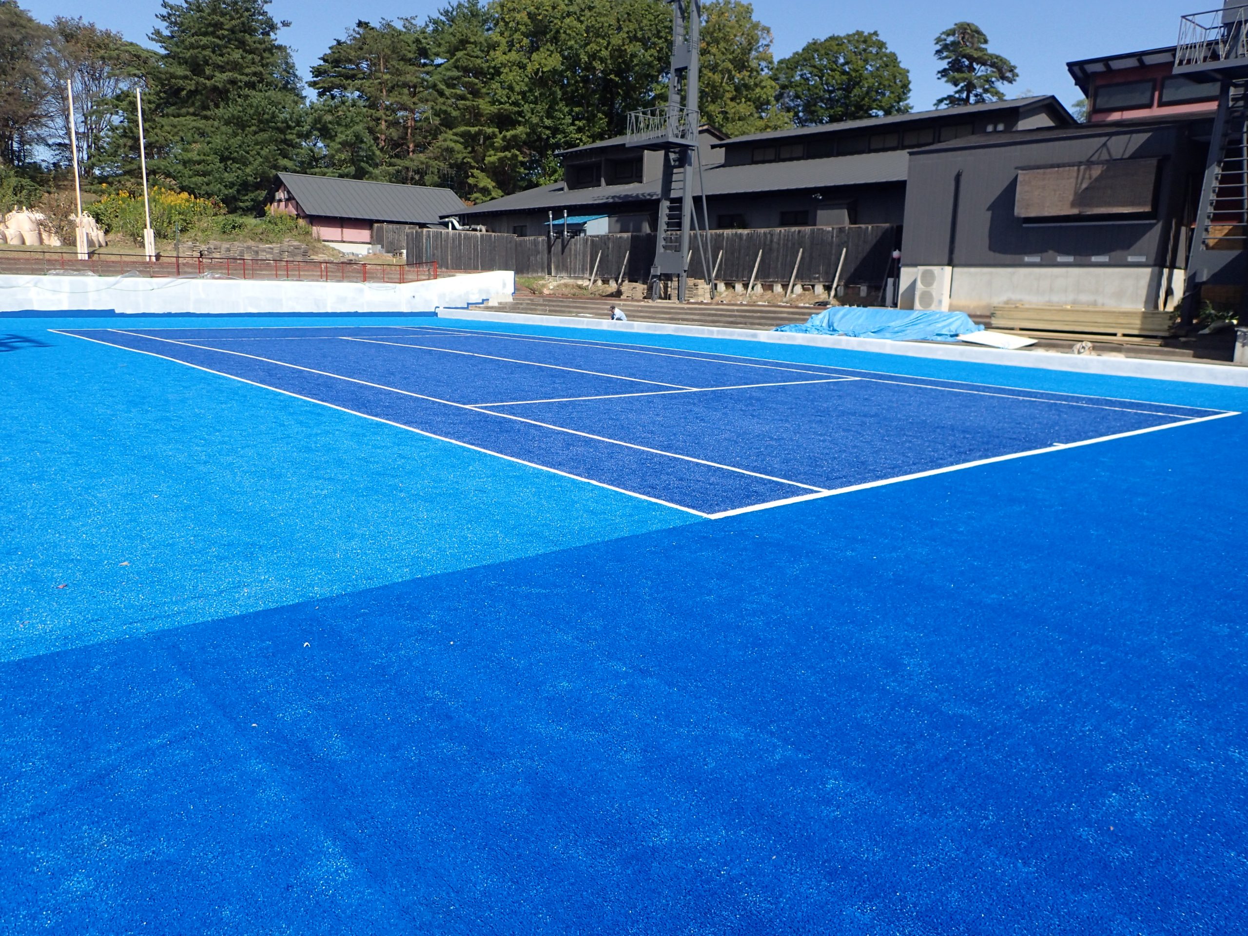 温泉リゾートのテニスコート｜サンドドレス人工芝・特注ディープブルー｜降雨後すぐ使える・映える