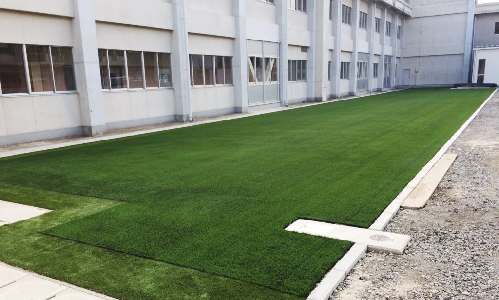 中学校のコンクリート中庭に施工した人工芝広場の全景（グランドプロ施工事例）