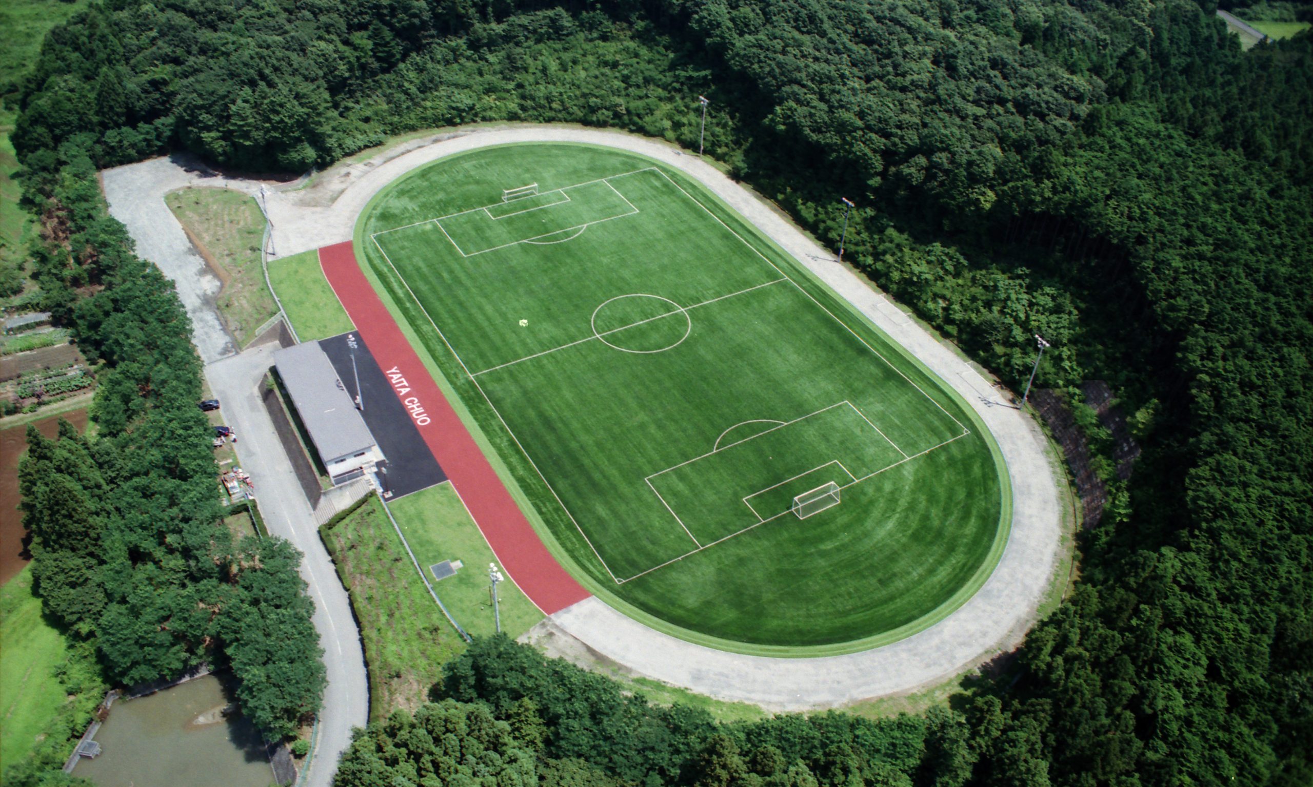 高校の専用サッカーコート|ロングパイル人工芝+弾性パッド|全天候・排水設計・白線は芝色分け